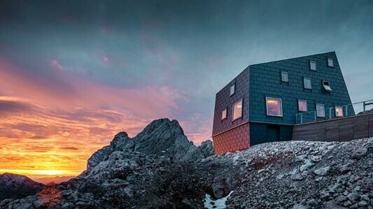 Usædvanlig arkitektur i bjergene: Seethalerhütte ved Dachstein inddækket med PREFA tag- samt facadepanel FX.12 i stengrå.