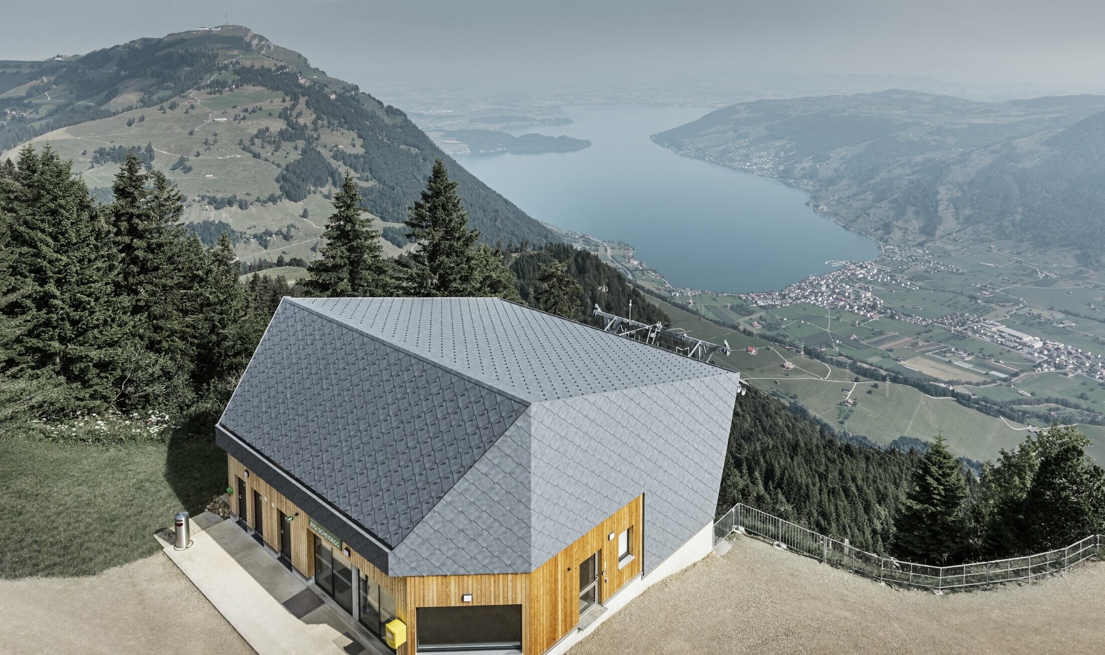 Luftfoto af bjergstationen ved Rigi Scheidegg-kabelbanen, beklædt med PREFA-vægrombe 44 × 44 i P.10 stengrå og træ.