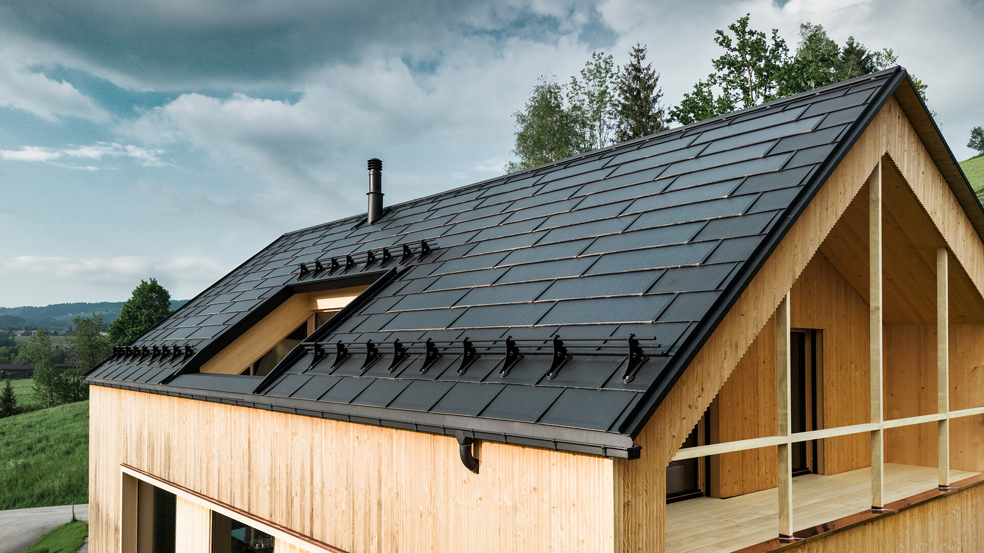 PREFA solcelletagplade i sort på et økohus i Egg, Østrig - holdbart, energieffektivt og æstetisk tiltalende for moderne arkitektur. Det innovative solcelletagplade kombinerer et stormsikkert tag med et fotovoltaisk system. De integrerede PV-moduler smelter harmonisk ind i taget på parcelhuset.