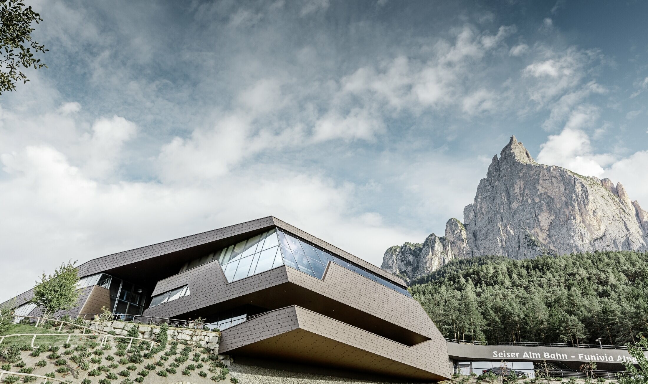 Ny formgivet dalstation til banen Seiser Alm, med Dolomitterne i baggrunden med uregelmæssige kanter og overflader med en aluminiumfacade i brun fra PREFA