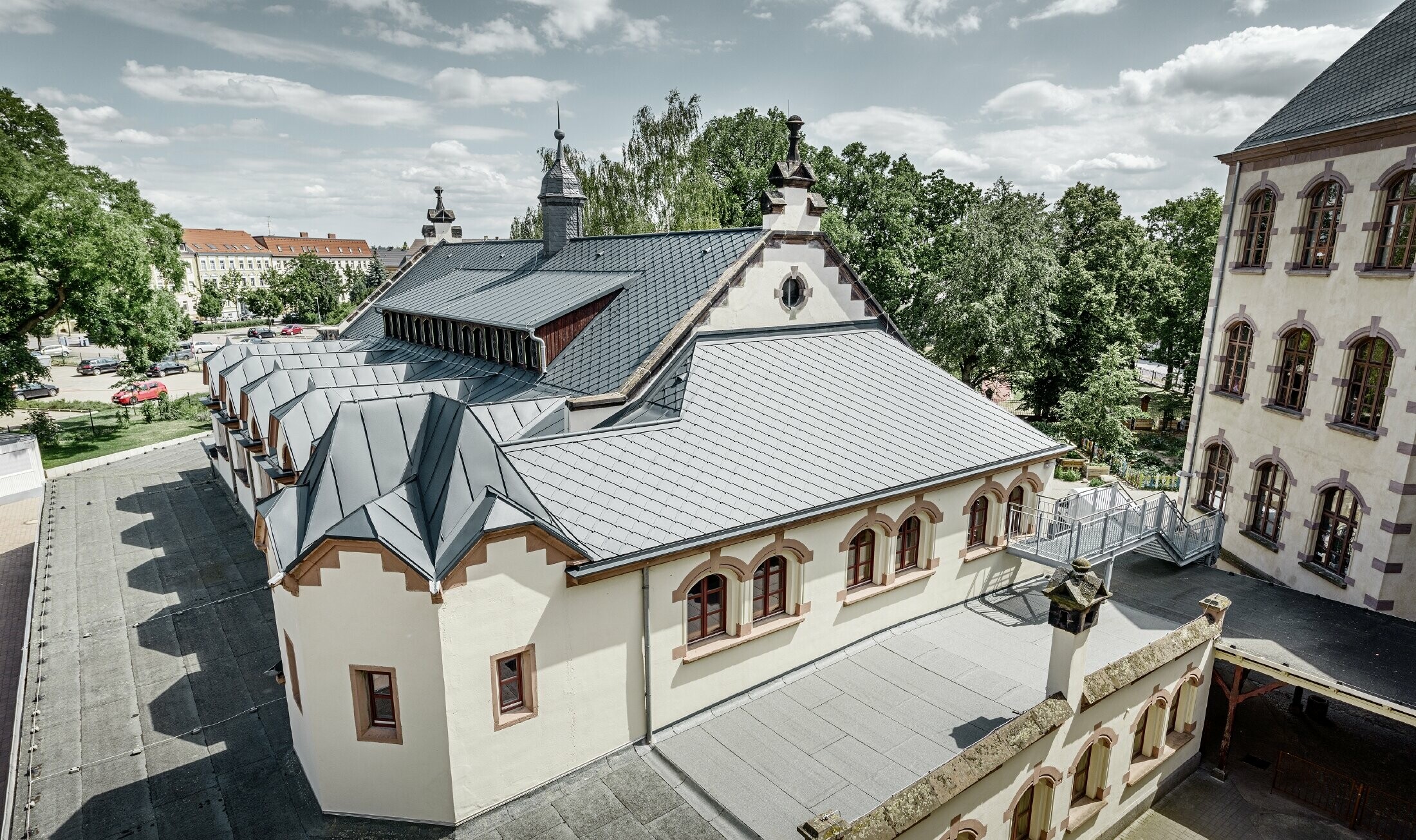 Frisk saneret gymnastiksal i skolen Lutherstadt Wittenberg med et PREFA aluminiumtag. Tagrombe og Prefalz blev lagt i antracit