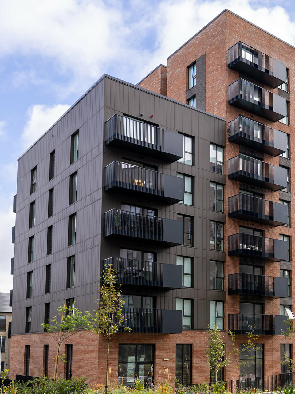 Frontansicht der Citywest Apartments in Dublin. Kombination aus traditioneller Ziegelfassade und 700 m² PREFA Sidings aus hochwertigem Blech in der Farbe P.10 Braun. Die Aluminiumpaneele verleihen dem Wohngebäude ein modernes, urbanes Erscheinungsbild mit hoher Witterungsbeständigkeit.