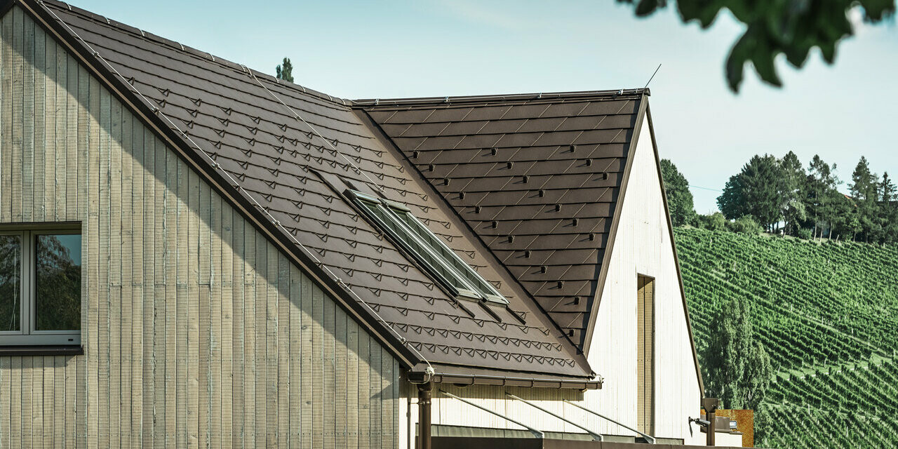 Enfamilieshuset med to sadeltag blev beklædt med PREFA-tagspån i nøddebrun. Tagafvandingen sker via den firkantede PREFA-tagrende. Facaden er beklædt med forvitret træfacade.