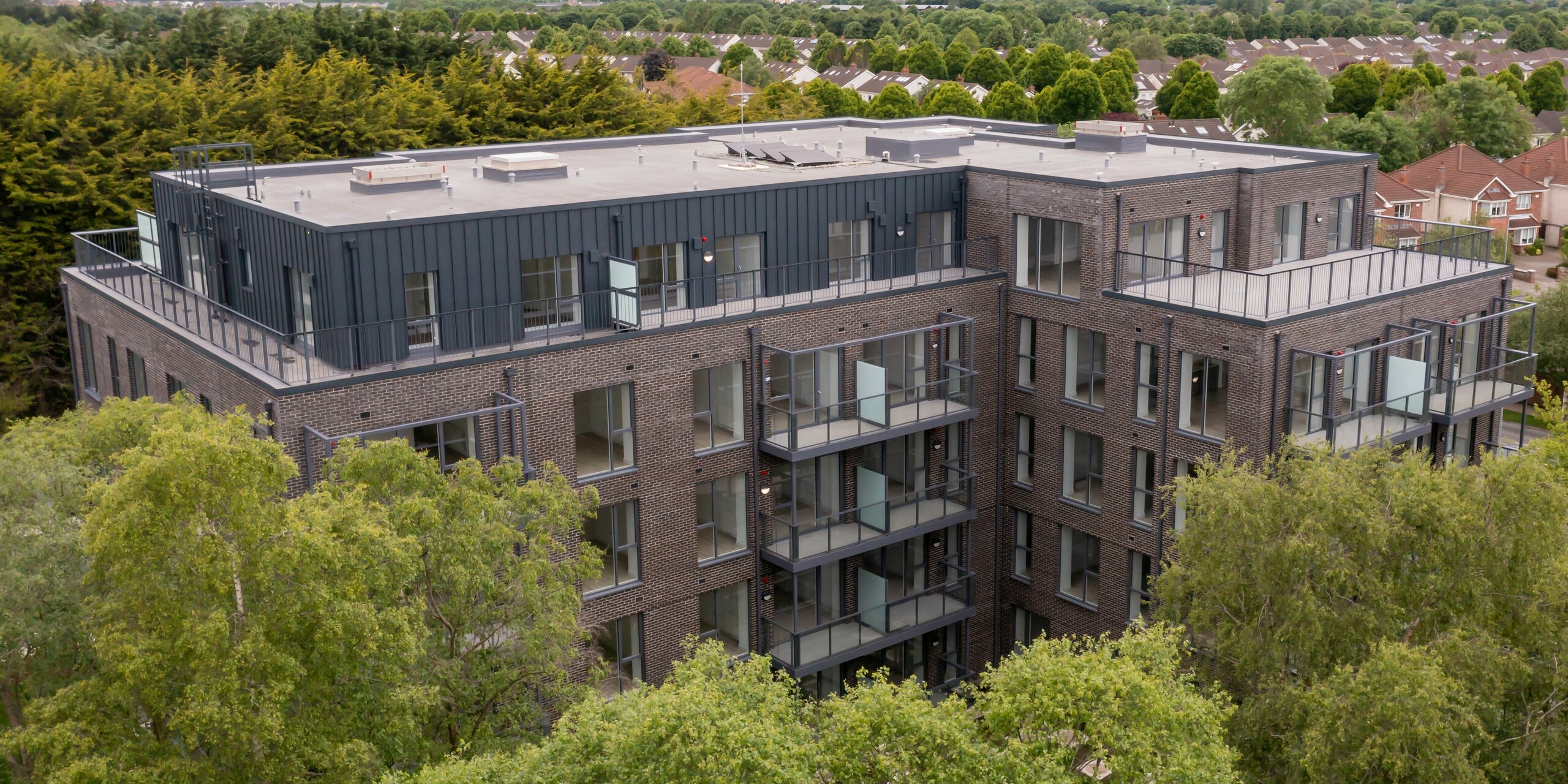 Luftaufnahme der Wohnanlage Balroy Hall in Carpenterstown, Dublin. PREFALZ P.10 anthrazit auf 800 m² wurde an der Fassade der Gebäude mit traditionellen Ziegelfassaden kombiniert. Perfekte Harmonie zwischen moderner Aluminiumverkleidung und klassischem Design in nachhaltiger Architektur.