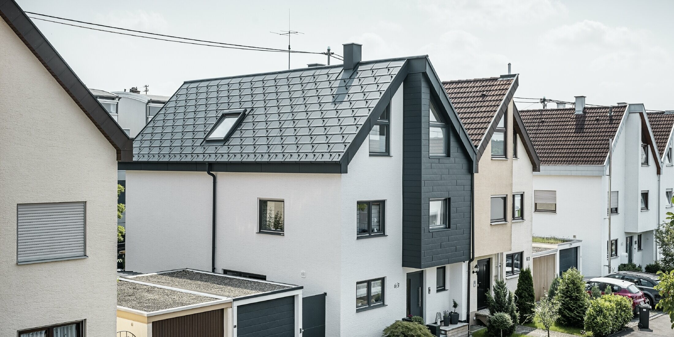 En dobbelthushalvdel blev allerede renoveret, med frisk hvid pudset facade, kombineret med en PREFA Siding.X-facade i antracit. Taget blev beklædt med PREFA-tagplade R.16. Tagafvandingen sker via den firkantede tagrende inklusive PREFA-nedløbsrør.